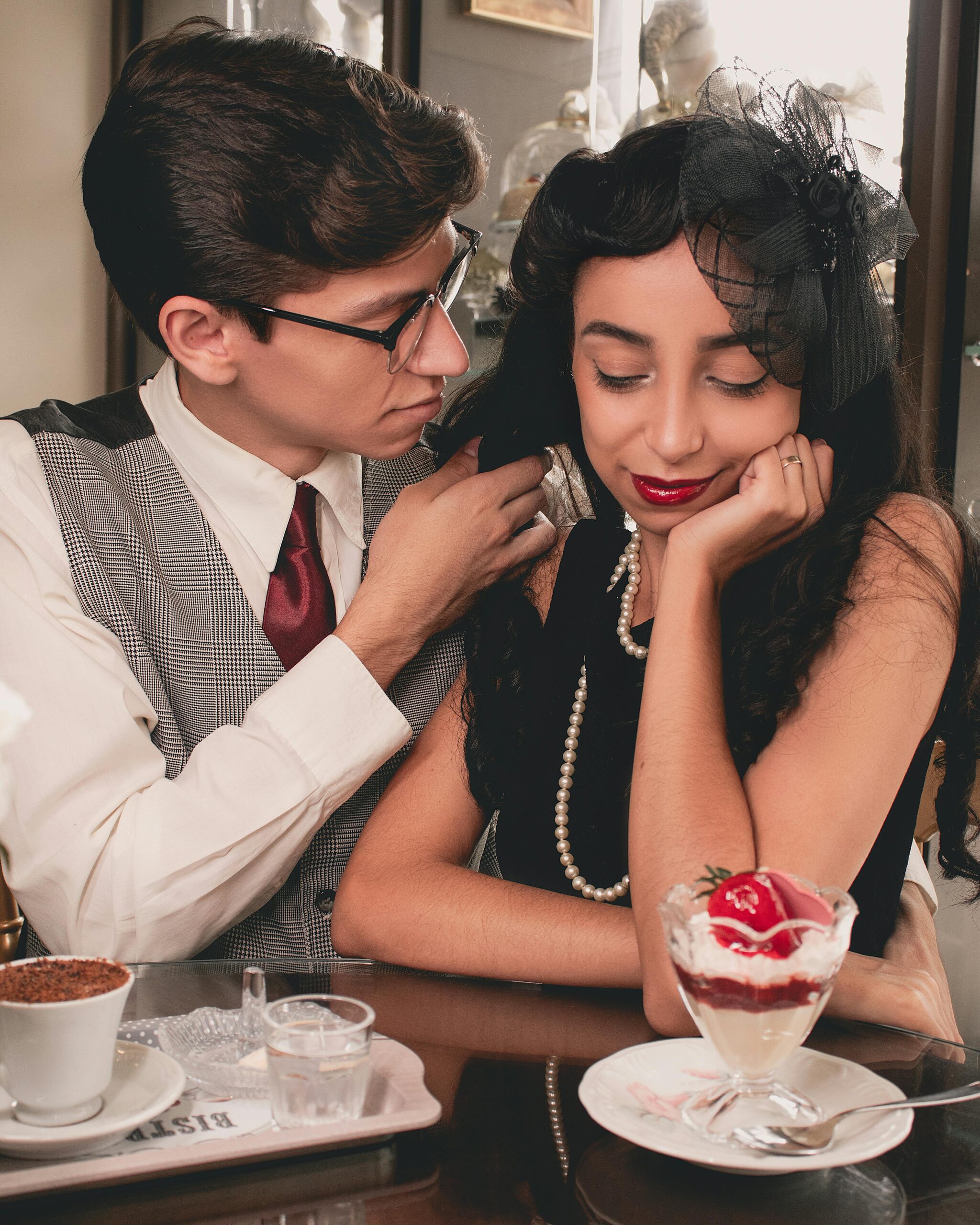 Charming vintage-themed couple enjoying a cozy date with dessert and coffee.